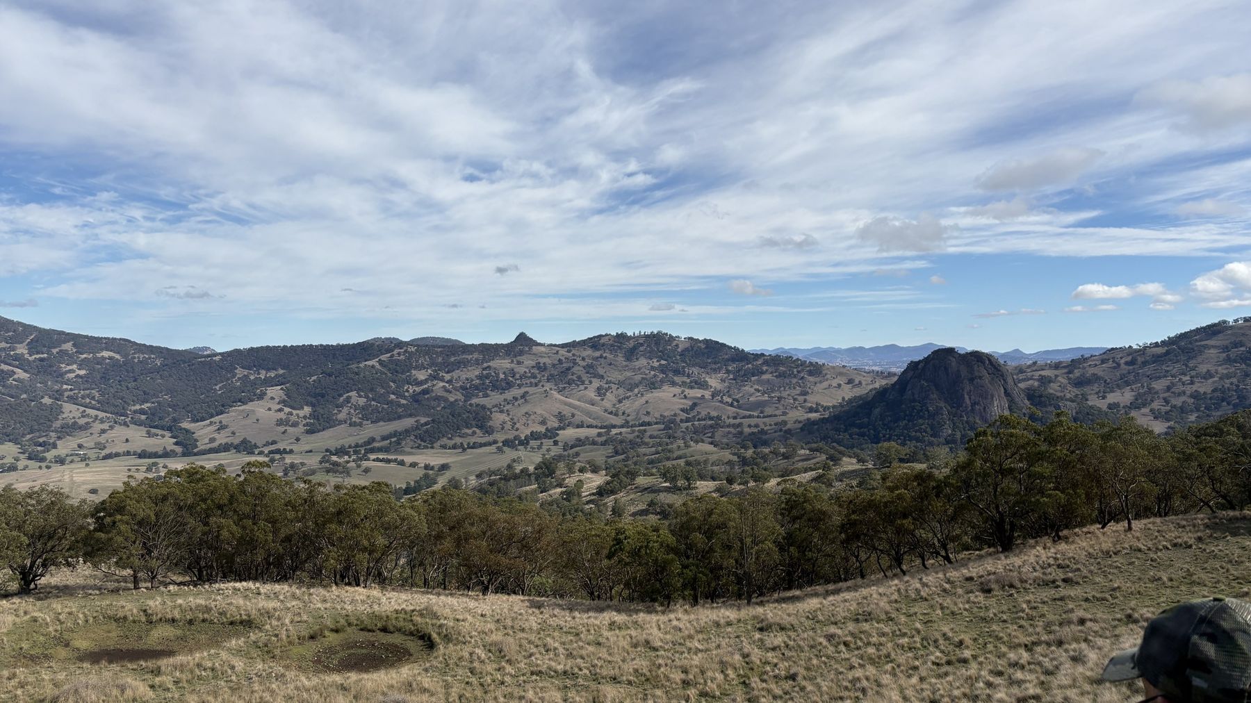 Timbered hills, open grass and a rocky outcrop in the Upper Hunter under a big sky